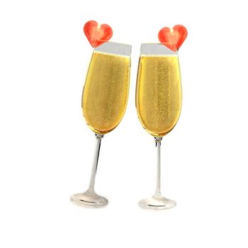 Two champagne glasses with two tomatoes on a white background which symbolizes love.