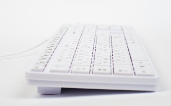 White keyboard with wire on isolated white background, close up view