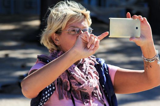 Woman taking a photo with her white smart phone