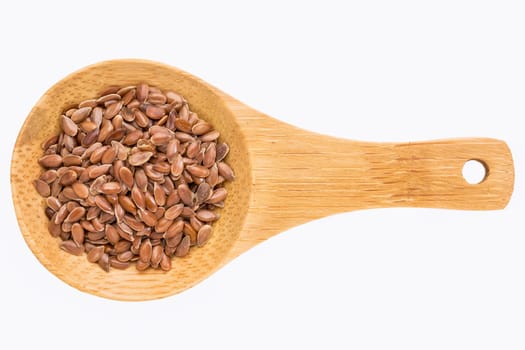 brown flax seeds on a small wooden spoon isolated on white with a clipping path
