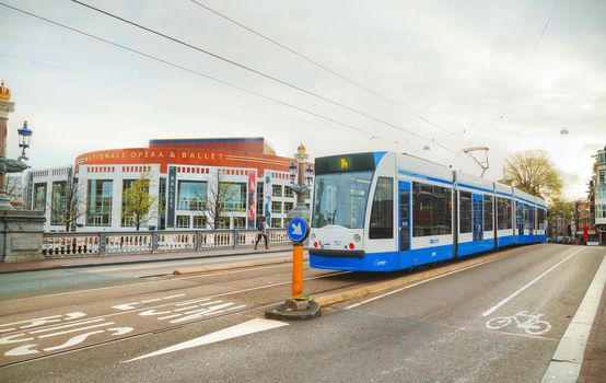 AMSTERDAM - APRIL 17: Tram near Nationale opera and ballet building (Stopera) on April 17, 2015 in Amsterdam, Netherlands. The Stopera is located in the center of Amsterdam.