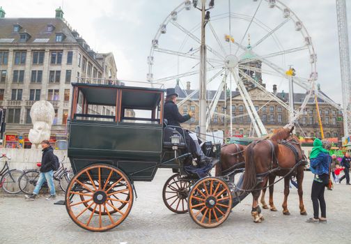 AMSTERDAM - APRIL 16: Horse cart at Dam square on April 16, 2015 in Amsterdam, Netherlands. It's the capital city and most populous city of the Kingdom of the Netherlands.