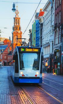 AMSTERDAM - APRIL 18: Tram near Munttoren tower on April 18, 2015 in Amsterdam, Netherlands. It stands on the busy Muntplein square, where the Amstel river and the Singel canal meet.