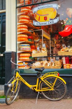 AMSTERDAM - APRIL 16: Bicycle parked near a grocery store on April 16, 2015 in Amsterdam, Netherlands. It's the capital city and most populous city of the Kingdom of the Netherlands.