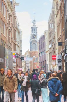 AMSTERDAM - APRIL 17: Narrow street crowded with tourists on April 17, 2015 in Amsterdam, Netherlands. It's the capital city and most populous city of the Kingdom of the Netherlands.