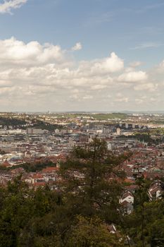 Scenic rooftop view of Stuttgart, Germany showing modern high-rise buildings amongst traditional historical architecture with view to the surrounding hills on a sunny day