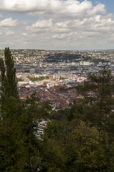 Scenic rooftop view of Stuttgart, Germany showing modern high-rise buildings amongst traditional historical architecture with view to the surrounding hills on a sunny day