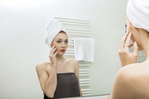 Close up Fresh Young Woman From Shower Looking her Face While Touching it In Front the Mirror