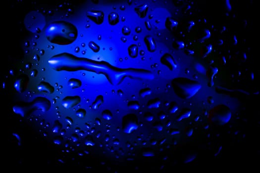blue abstract background with water drops on glass for background or backdrop