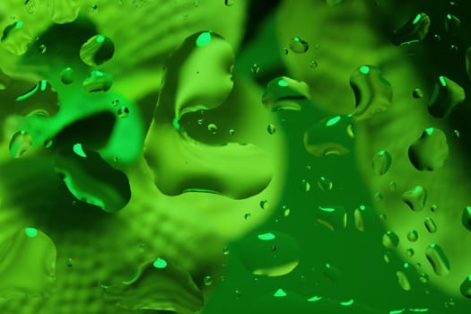 green abstract background with water drops on glass for background or backdrop