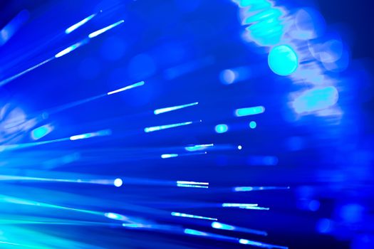 bunch of optical fibres flying from deep as blurred abstract technology background