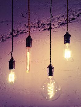Illuminated light bulbs on purple background. Industrial design.