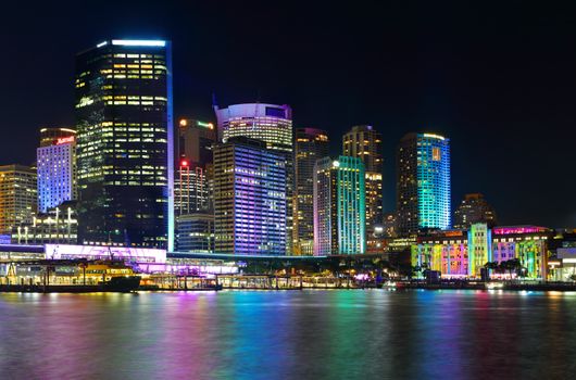 SYDNEY, AUSTRALIA - MAY 25, 2015; Sydney city CBD and Circular Quay by night.  Buildings illuminated with colour during Vivid Sydney annual festival event.