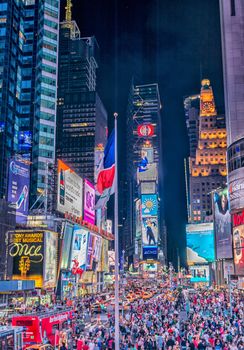 NEW YORK CITY - JUNE 8, 2013: Tourists in Times Square at night. More than 50 million people visit New York every year.