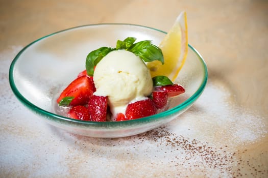 Ice cream with fresh strawberries in glass bowl