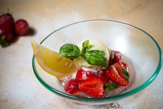 Ice cream with fresh strawberries in glass bowl