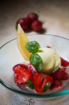 Ice cream with fresh strawberries in glass bowl
