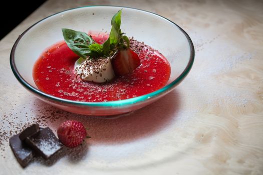 strawberry soup with ice cream and mint on a plate decorated fresh strawberries and chocolate