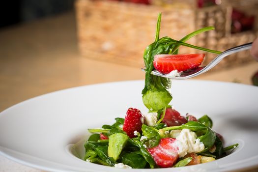 Fresh Salad with strawberries, goat cheese and shrimps dressed with balsamic vinegar and olive oil