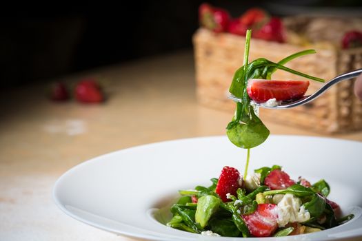 Fresh Salad with strawberries, goat cheese and shrimps dressed with balsamic vinegar and olive oil