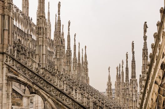 Detail view of stone sculptures on roofs of Duomo Milano, Italy