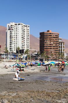 IQUIQUE, CHILE - FEBRUARY 10, 2015: Unidentified people on sandy Cavancha beach on February 10, 2015 in Iquique, Chile. Iquique is a popular beach town and free port city in Northern Chile. 