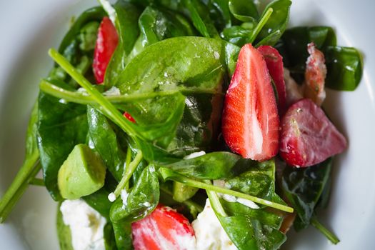 Fresh Salad with strawberries, goat cheese and shrimps dressed with balsamic vinegar and olive oil