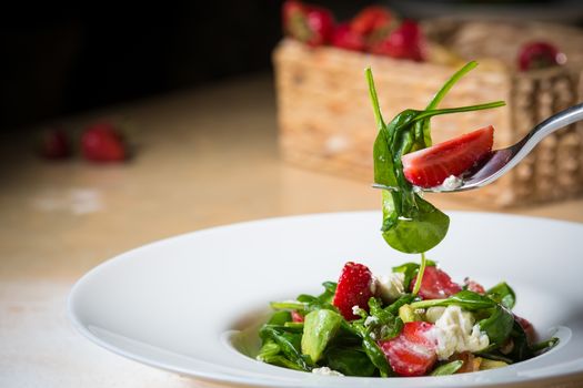 Fresh Salad with strawberries, goat cheese and shrimps dressed with balsamic vinegar and olive oil