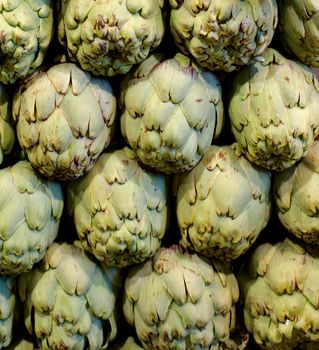 Background of Raw Ripe Artichokes Outdoors on Farmer Market Stand