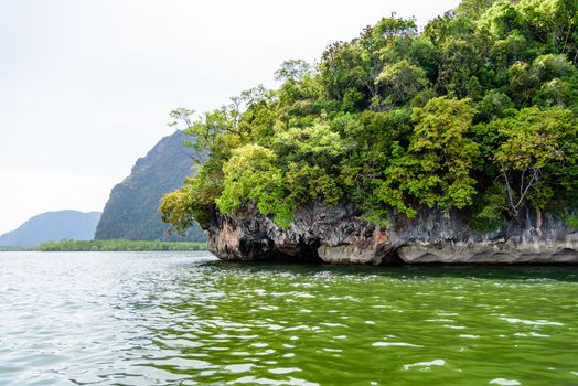 Beautiful scenery of the island and the green sea during travel by boat in Phang Nga Bay or Ao Phang Nga National Park, Thailand