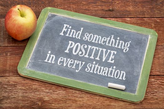 Find something positive in every situation  - motivational  words on a slate blackboard against red barn wood