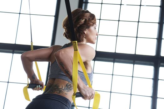 TRX. Beautiful woman at gym