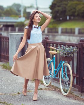 Young beautiful, elegantly dressed woman with bicycle. Beauty, fashion and lifestyle