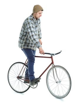 Young man doing tricks on fixed gear bicycle on a white background