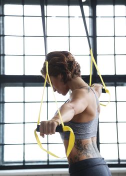 TRX. Beautiful woman at gym