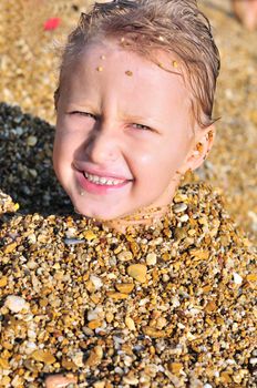 funny boy on the beach in sand 