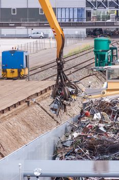 Open barge being loaded or offloaded at a wharf on an urban waterway or river by a heavy duty industrial crane