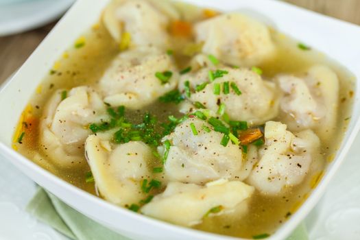 Dish of savory tortellini pasta filled with pork in a tasty broth seasoned with fresh herbs and served for dinner