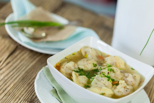 Dish of savory tortellini pasta filled with pork in a tasty broth seasoned with fresh herbs and served for dinner