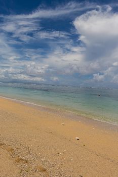 Beautiful tropical beach with lush vegetation fringing golden sand and a tranquil ocean with gentle surf breaking on the beach