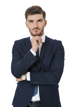 Stylish successful handsome young businessman standing in a relaxed pose with his hands in his pockets and his suit jacket open, isolated on white