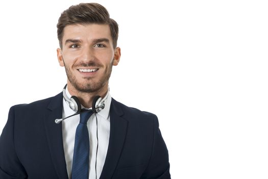 Young bearded handsome man wearing formal business suit and headset with stereo headphones and microphone while smiling at camera, portrait on white