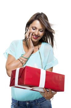 Close up Portrait of Happy Young Woman in Casual Clothing Holding a Red Big Gift Box with White Ribbon While Looking at the Camera. Isolated on White Background.