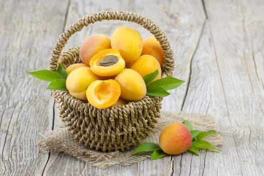 fresh apricots in a basket on wooden background