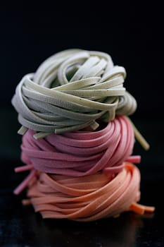 colorful pasta tagliatelle on a black background