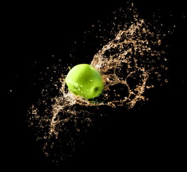 Green apple with water splash on black background