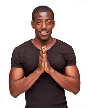 Closeup portrait of handsome young black african smiling man, isolated on white background. Positive human emotions. hands folded in a gesture of greeting