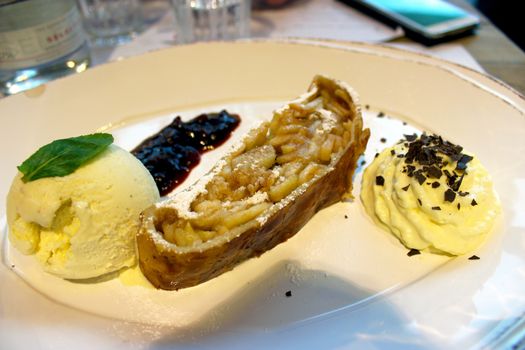 Apricot tarte tatin with vanilla ice cream on a white plate - Restaurant in Germany
