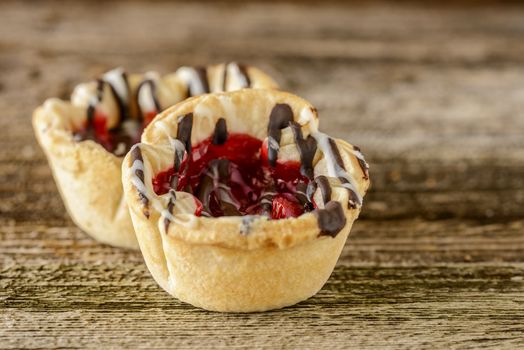 Homemade cherry tarts with chocolate and vanilla icing.