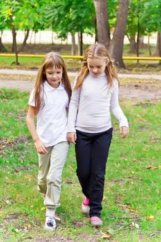 Photo of two walking girls in summer